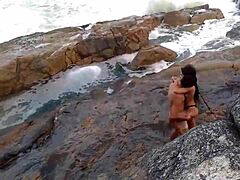 一个成熟的非洲女人拥有天然的乳房,在海滩前被操